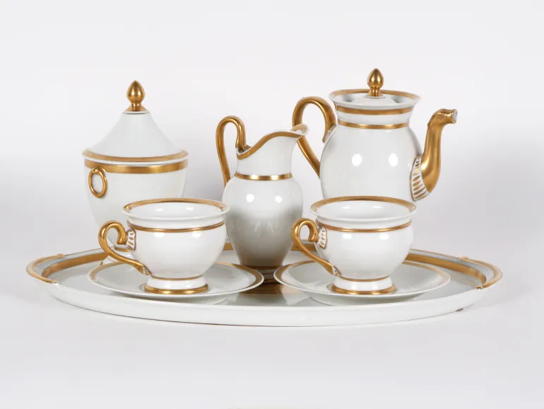 Limoges Porcelain IB02457 طقم tête-à-tête إمبراطوري من خزف أبيض ومذهّب، يظهر مع صينية وإبريق شاي وسكرية ووعاء قشدة وفنجانين.