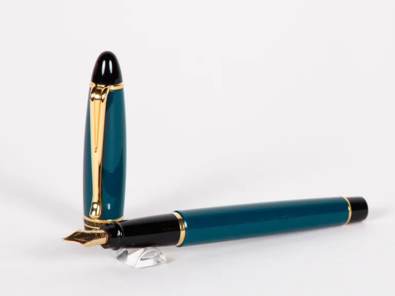Stylo plume Aurora Ipsilon vert à garniture dorée, SKU IB02715, montré avec le capuchon debout et la plume posée.