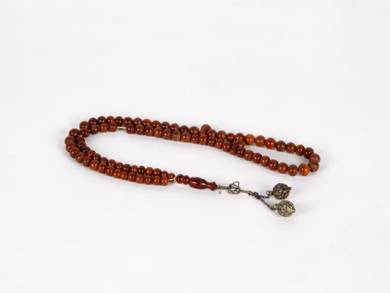 IB03616 chapelet Masbaha en ancien bois de Kouk, 99 grains ronds bruns et pendant en argent, sur fond blanc.