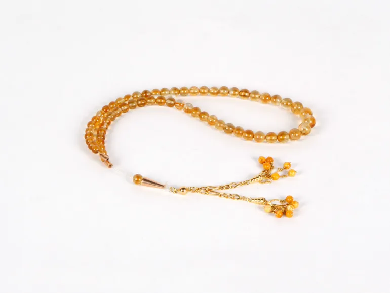 IB03618 Masbaha rosary with natural topaz beads and gold pendant, shown on white background.