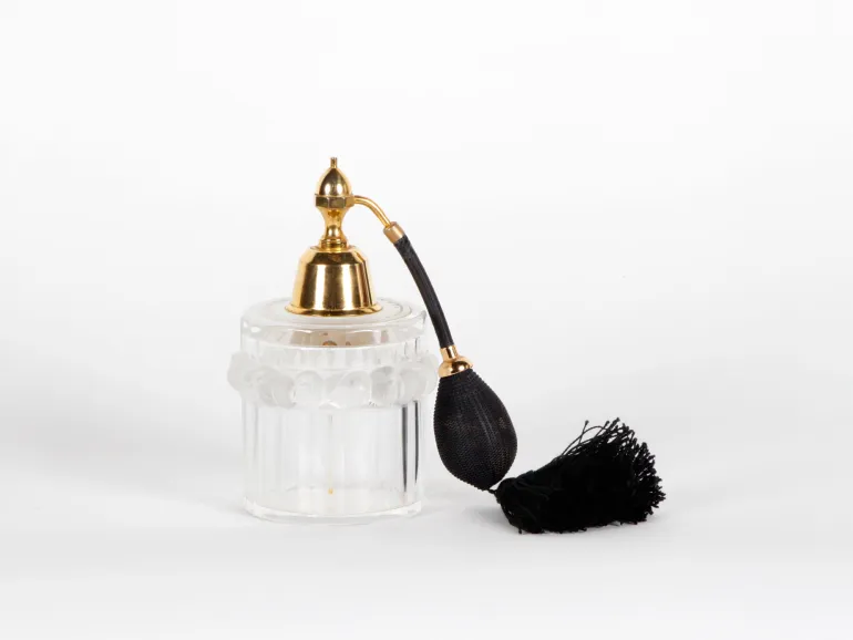 Lalique vaporizer flask, SKU IB04063, clear crystal with gold-tone sprayer and black bulb, shown with diffuser.