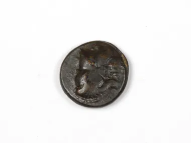 Greek bronze coin Pamphylia Side, SKU IB03411, showing a helmeted head on a dark worn surface.