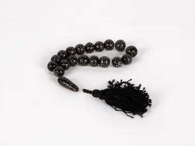 Black Coral Masbaha, SKU IB03630, with 18 dark spotted beads and a black braided tassel on white background.
