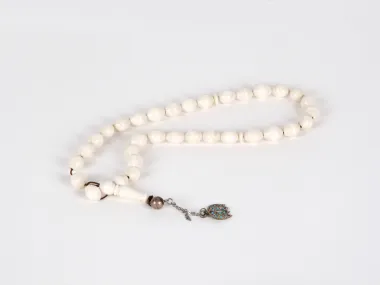 IB03653 Masbaha rosary with 33 ivory oval beads and a silver pendant with turquoise inlay, shown on a white background.