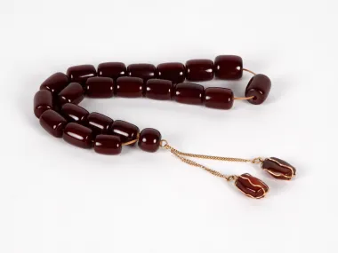 IB03657: Amber and gold Masbaha rosary with dark amber beads and two gold pendants on a white background.