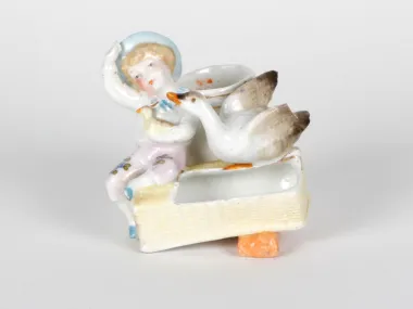 IB05067 porcelain sculpture of a child with a goose and basket, painted and enameled, Germany, late 19th century.