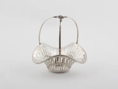 IB08132: سلة من الفضة الإسترليني من القرن التاسع عشر، بتصميم مفرغ ومقبض على شكل شريط، على خلفية بيضاء.