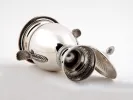 IB00029 sterling silver covered jar with two handles, guilloched body and lid, shown on its side on a white background.