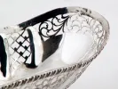 IB00816 openwork oval sterling silver basket with ornate pierced sides and four feet, close-up view.