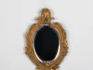 IB01282 gilded bronze Rocaille dressing table mirror with oval beveled glass and ornate floral frame.