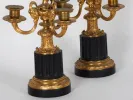 Pair of Napoleon III bronze chandeliers, IB01828, shown with gilded ram-head arms and black fluted marble pedestals.