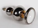 IB01916 Ceramic lamp base, 1960s, shown with two silver-and-gold ceramic spheres and a large silver lampshade.