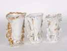 IB02435: Three white and gold openwork porcelain vases with handles, shown together.