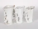 IB02435: three white and gilt openwork porcelain vases with handles, shown together on a plain background.