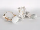 IB02435: Three white and gold openwork porcelain vases with handles, shown lying on a white background.