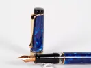 Stylo plume Aurora IB02695 Optima bleu à garniture dorée et plume 14 cts, avec capuchon et plume visibles.