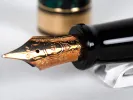 Aurora Optima fountain pen nib in close-up, gold 14K nib with black barrel, SKU IB02808.