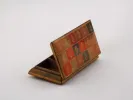 IB03196 علبة من الجلد المحدب بغطاء مفصلي وثلاث حُجُرات، مزخرفة بزخارف ميداليات على ألواح حمراء وذهبية وداكنة.