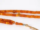 Masbaha rosary in old Indian amber with silver pendant, SKU IB03644, shown with orange bead strands on a white background.
