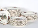 IB03927 Obernai Sarreguemines earthenware table set: stacked white plates with floral borders and village scenes.