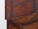 IB04199 Coffre en bois, fin 18e siècle, en noyer foncé avec décor floral sculpté et ferrures métalliques, vu ouvert en gros plan.
