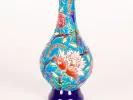 مزهريّة بزهرة واحدة من Longwy Ceramic، SKU IB04427، بزخرفة زهور نافرة ملوّنة على خلفية زرقاء.
