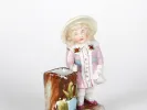 IB05065 porcelain sculpture of a girl in a pink dress with a hat, standing beside a basket; painted and enameled porcelain.
