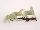 SKU IB05075: three small jade horse figurines on wooden stands, shown in pale green serpentine.