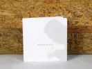 SKU IB05169 : livret ou catalogue de l’artiste Young-Sé Lee, présenté debout, avec son nom sur une couverture blanche devant une œuvre texturée.
