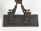 IB05729 de Monkith Saaid : sculpture en bronze patiné de chaises empilées sur un socle noir, vue en gros plan.