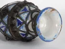 IB06326 ceramic Moroccan jug, blue and white with silver filigree, shown on its side with the base visible.