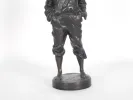 Sculpture en bronze de Victor Szczblewski « Le Mousse Siffleur » - IB06428, montrant le bas d’une figure debout sur un socle rond.