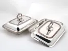 IB06720 Paire de légumiers anglais en métal argenté à bordure tressée, avec couvercles et poignées amovibles, sur fond blanc.