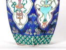 IB07203 vase hexagonal en porcelaine bleue avec décor floral et bordure géométrique, vu en gros plan ; couvercle manquant.