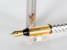 Cartier Trinity 3 fountain pen, SKU IB07755, with gold nib and silver-gold striped barrel shown on a stand.