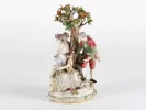 Groupe en porcelaine Meissen Autour d'un arbre, SKU IB08062, montrant une femme à la mandoline, un gentilhomme avec des fleurs et un enfant près d'un arbre.