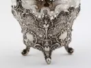 IB08127 Victor Nuber sterling silver basket with ornate floral scrollwork and four feet, shown with glass insert.