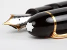 Montblanc Pens & Accessories IB08921 Meisterstuck 149 fountain pen with black resin body, gold trim and 18k nib, close-up on white background.