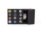 Swatch IB09226 Mission to Saturn Moonwatch chronograph in black box, watch partially visible beside OMEGA x Swatch packaging.