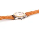 Montre bracelet Hermès Captain Nemo, SKU IB09290, avec cadran blanc, boîtier rond en acier et métal doré, et bracelet orange en lézard.