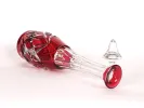 SKU IB09389: large red cut crystal carafe lying on its side, with faceted body and clear stem.