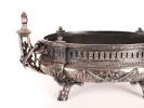 IB09550 Late 19th century silver-plated bronze jardinière, oval with ornate handles, hoof feet, and decorative laurel and trophy motifs.