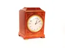 IB09561 Edwardian inlaid desk clock in marquetry wood with round dial and copper feet, shown front view.