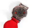 Top view of round watch with red strap, black and yellow markings on dial.
